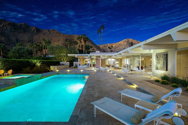 view of pool featuring an in ground hot tub, a mountain view, and a patio