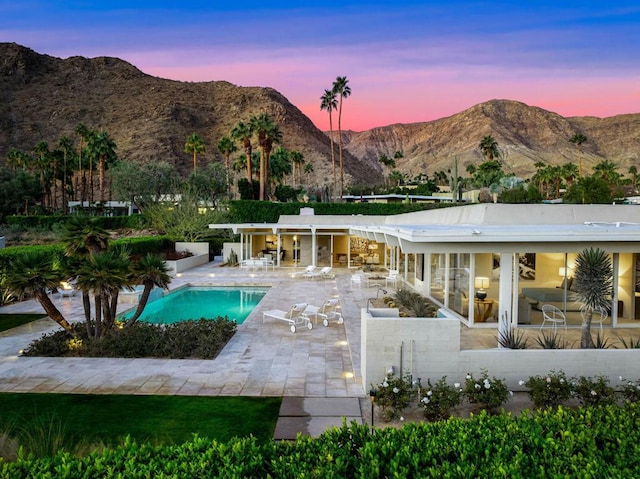 exterior space with a mountain view, a swimming pool, and a patio area