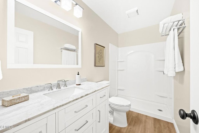 bathroom featuring vanity, hardwood / wood-style floors, walk in shower, and toilet