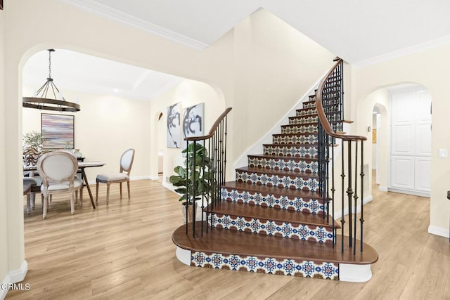 staircase featuring crown molding and hardwood / wood-style floors