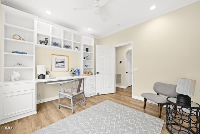 office with crown molding, ceiling fan, built in desk, and light hardwood / wood-style floors