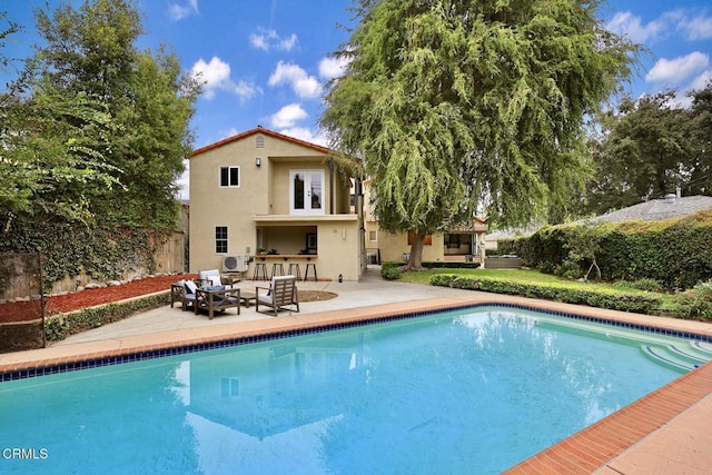 view of pool featuring exterior bar and a patio