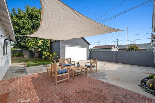 view of patio / terrace with an outbuilding, a garage, and an outdoor hangout area