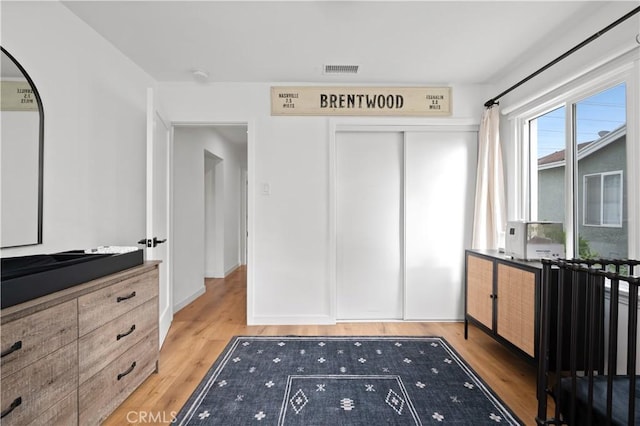 unfurnished bedroom with light wood-type flooring and a closet