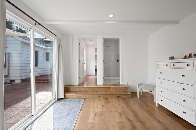 interior space with access to outside, beam ceiling, and light hardwood / wood-style floors