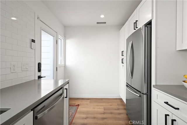 kitchen featuring white cabinetry, light hardwood / wood-style flooring, and appliances with stainless steel finishes