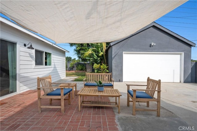 view of patio featuring a garage, an outdoor structure, and an outdoor hangout area