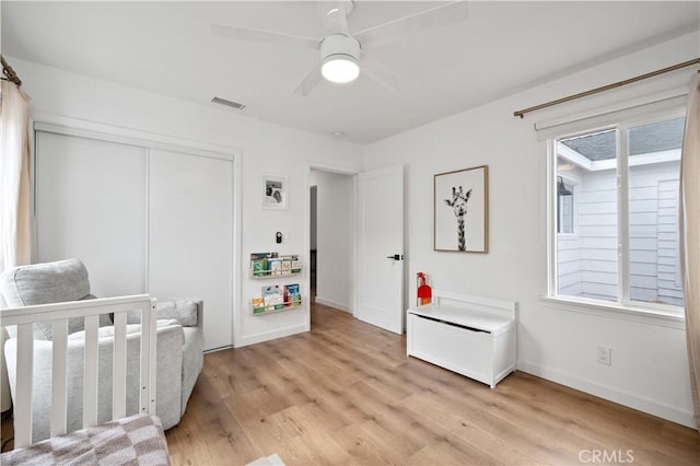 bedroom featuring light hardwood / wood-style flooring, a closet, and ceiling fan