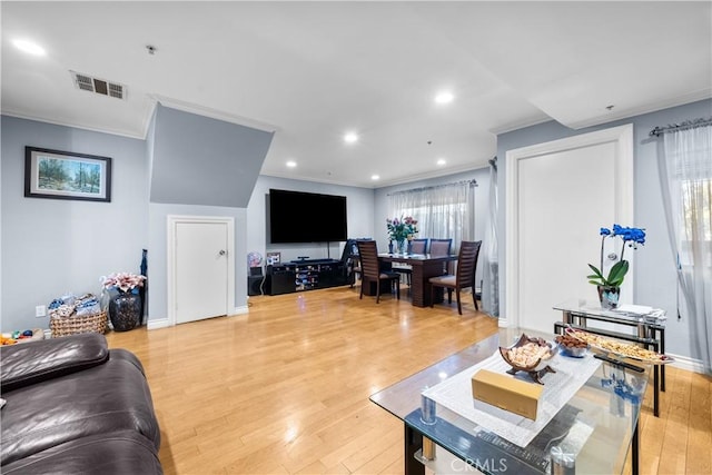 living room with ornamental molding, plenty of natural light, and light hardwood / wood-style flooring