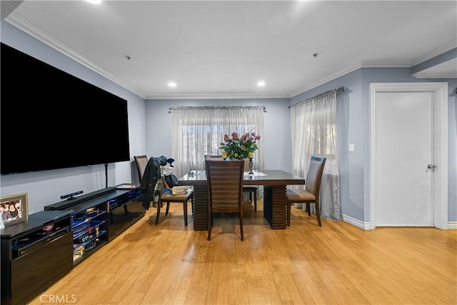 dining area featuring crown molding and light hardwood / wood-style flooring