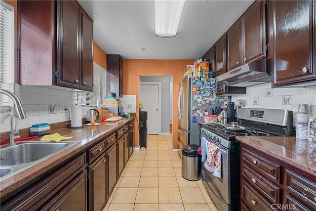 kitchen featuring light tile patterned flooring, sink, decorative backsplash, and stainless steel gas range oven