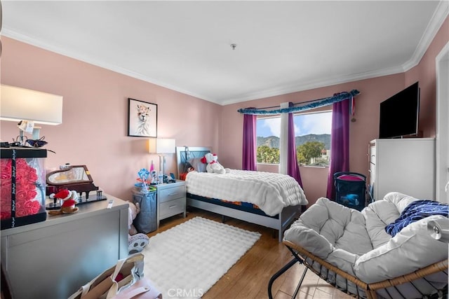 bedroom featuring wood-type flooring and ornamental molding