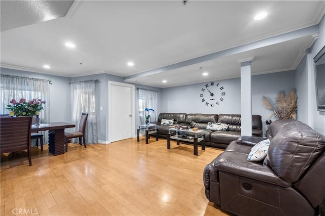 living room with ornamental molding and light hardwood / wood-style flooring