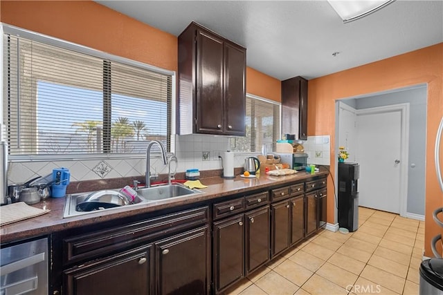 kitchen with backsplash, sink, dark brown cabinets, and light tile patterned floors