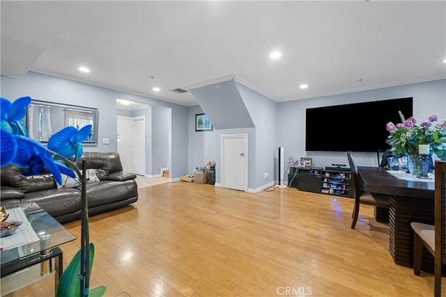 living room featuring crown molding and light wood-type flooring