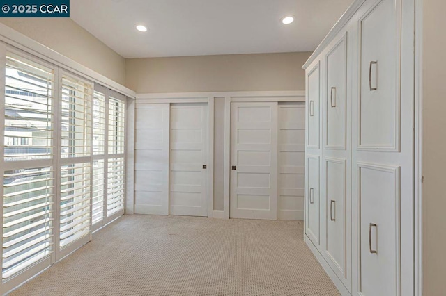 unfurnished bedroom with light carpet and two closets