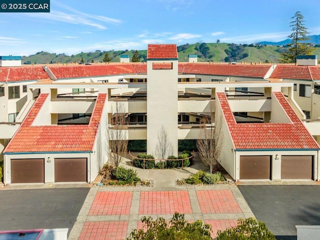 view of building exterior featuring a garage and a mountain view