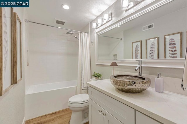 full bathroom with vanity, hardwood / wood-style floors, shower / bath combo with shower curtain, and toilet