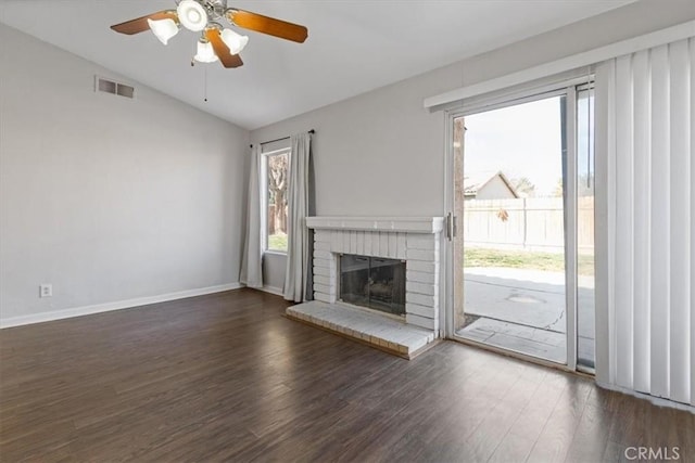 unfurnished living room with ceiling fan, lofted ceiling, dark hardwood / wood-style flooring, and a brick fireplace