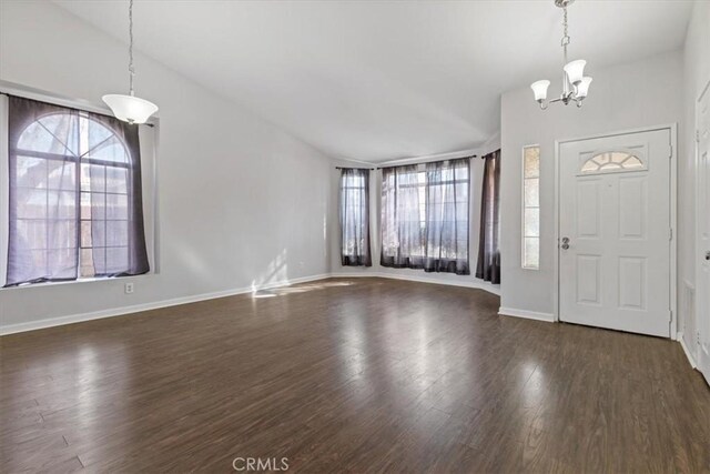 foyer with an inviting chandelier and dark hardwood / wood-style flooring