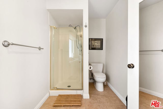 bathroom featuring tile patterned flooring, toilet, and walk in shower