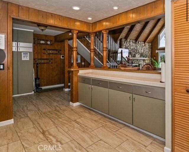 kitchen with vaulted ceiling with beams and wooden walls