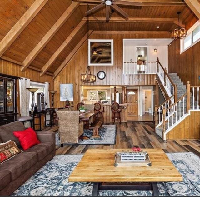 living room with hardwood / wood-style floors, beam ceiling, wooden ceiling, and wood walls