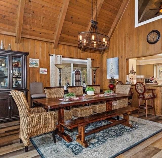 dining room with vaulted ceiling with beams, ceiling fan with notable chandelier, wood ceiling, and light hardwood / wood-style floors