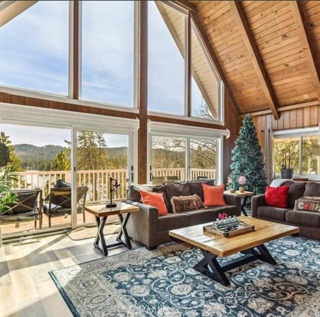 sunroom featuring wood ceiling, a wealth of natural light, and lofted ceiling with beams