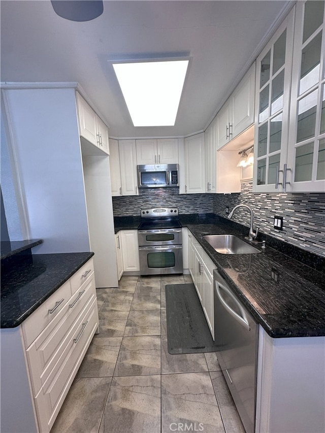 kitchen with white cabinetry, sink, dark stone counters, and appliances with stainless steel finishes