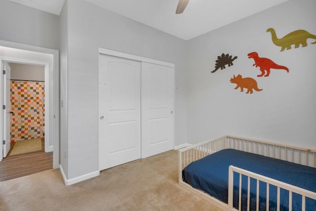 carpeted bedroom featuring ceiling fan and a closet