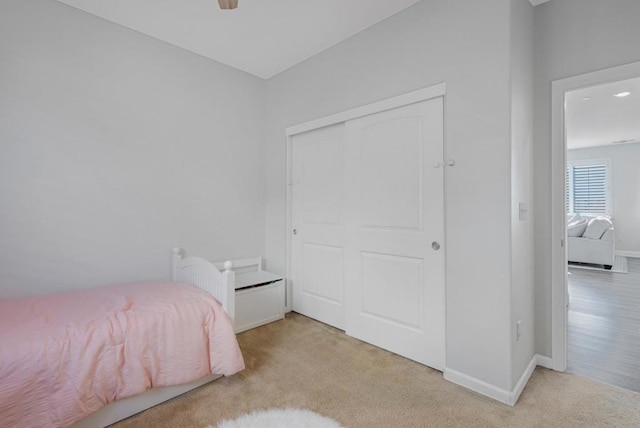 bedroom featuring light carpet and a closet