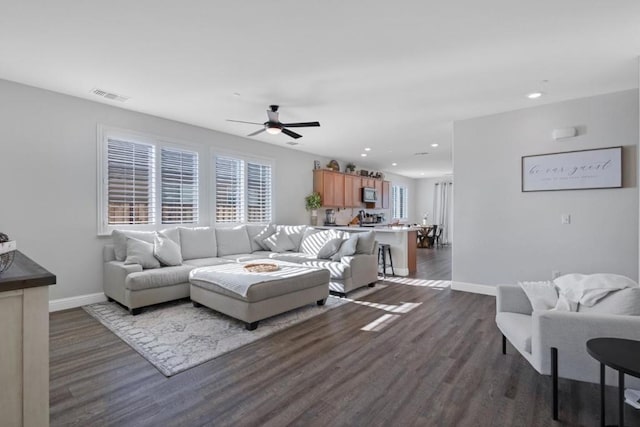 living room featuring ceiling fan and dark hardwood / wood-style flooring