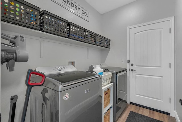 laundry room featuring separate washer and dryer and light hardwood / wood-style floors