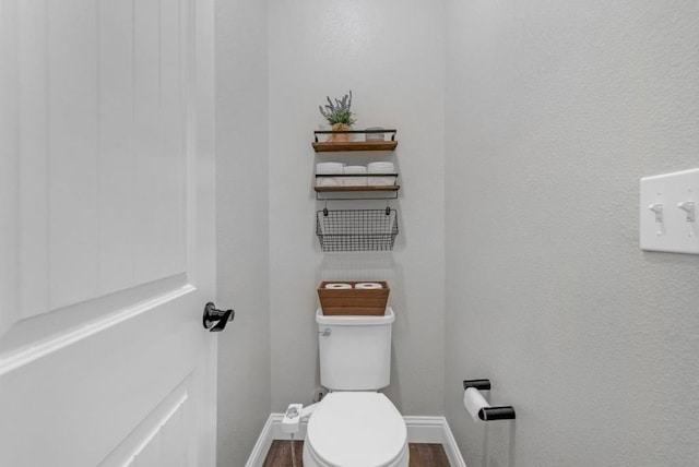 bathroom featuring hardwood / wood-style flooring and toilet