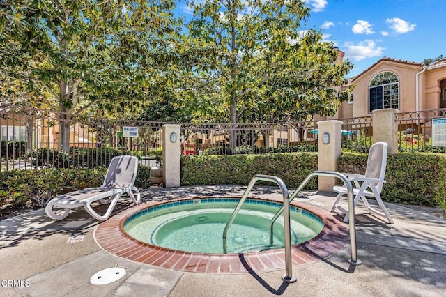 view of swimming pool with a hot tub