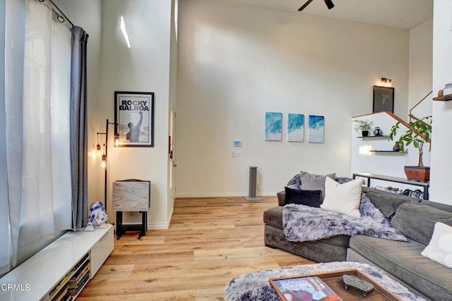 living room featuring light hardwood / wood-style flooring and ceiling fan