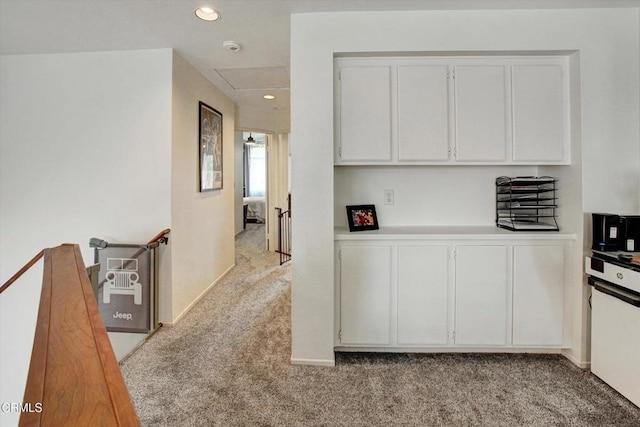 kitchen with white cabinetry and light colored carpet