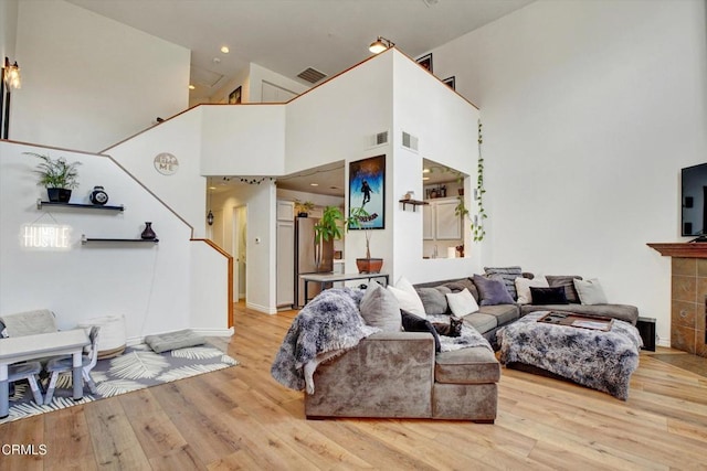 living room with a high ceiling and light wood-type flooring