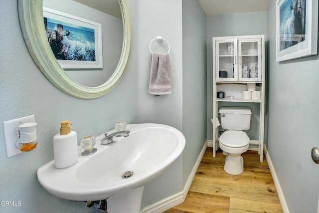 bathroom featuring wood-type flooring, toilet, and sink