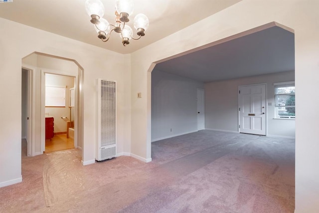 carpeted empty room with a chandelier