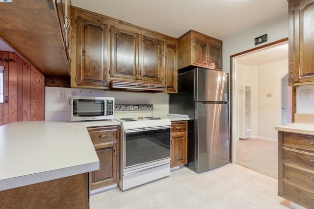 kitchen with appliances with stainless steel finishes and wood walls