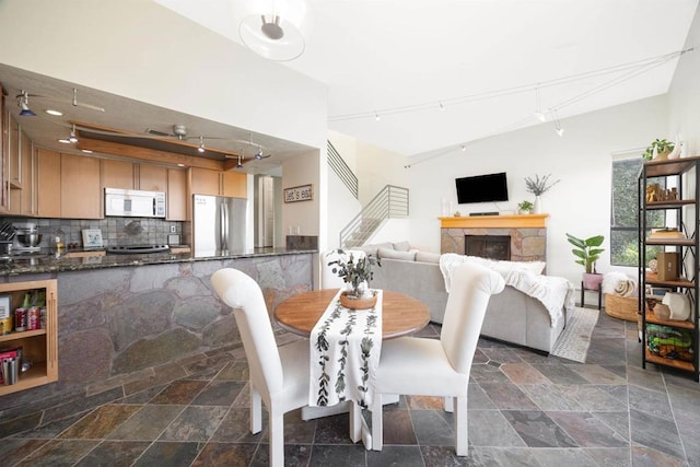 dining space with a fireplace and track lighting