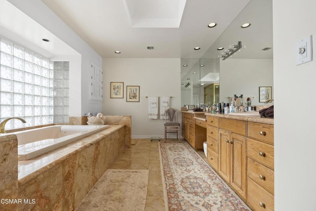 bathroom featuring vanity and tiled bath