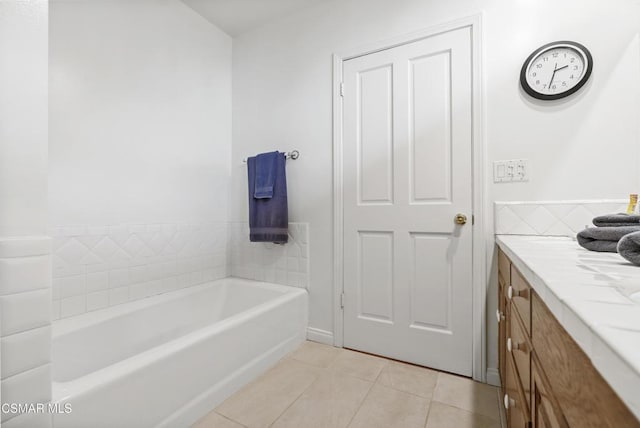 bathroom with tile patterned flooring, vanity, and a tub