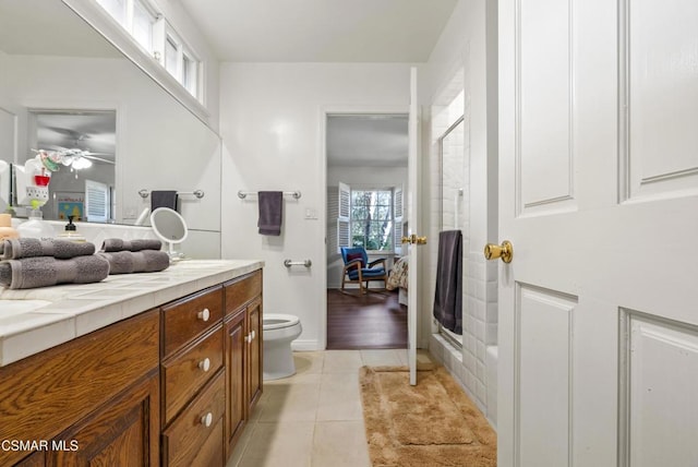 bathroom with tile patterned floors, toilet, an enclosed shower, and vanity