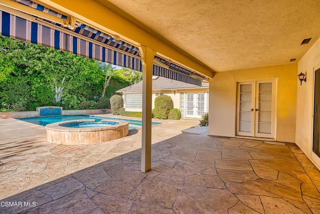 view of swimming pool with french doors, an in ground hot tub, and a patio area