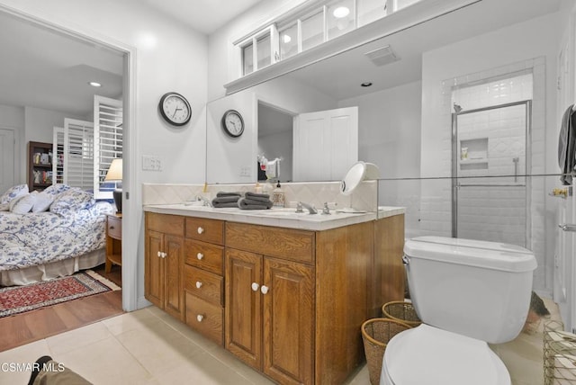 bathroom with a shower with shower door, decorative backsplash, tile patterned flooring, vanity, and toilet