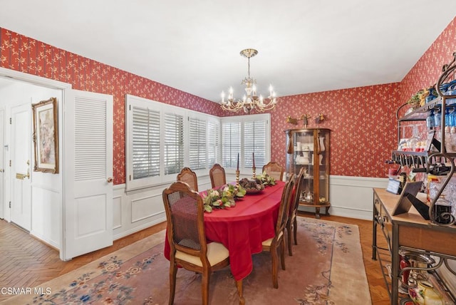 dining space with parquet flooring and a chandelier