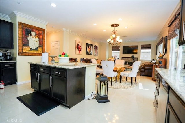 kitchen featuring crown molding, a center island, hanging light fixtures, and light stone countertops